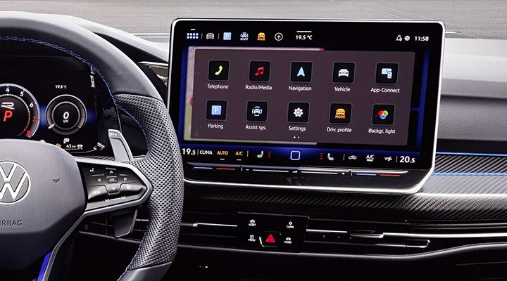 Interior view showing the sport steering wheel and the large infotainment touchscreen displaying the main app interface.