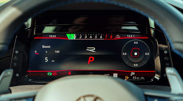 Close-up of a car's Digital Cockpit dashboard, displaying engine performance information and the R logo.