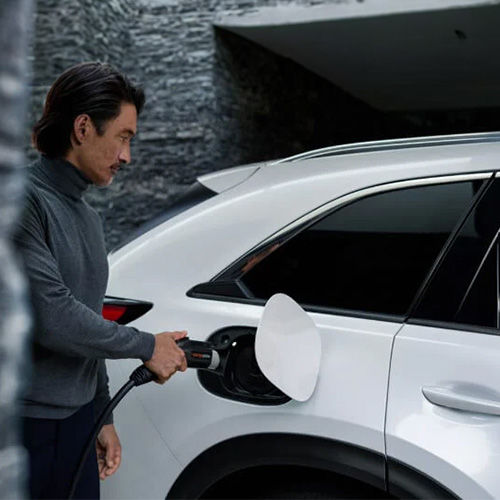 Driver plugging charger cord into CX-90 PHEV.  