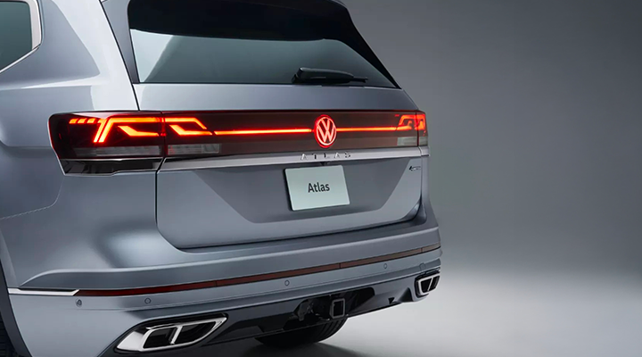 Close-up rear view of a gray Volkswagen Atlas SUV with a visible towing hitch receiver below the bumper.