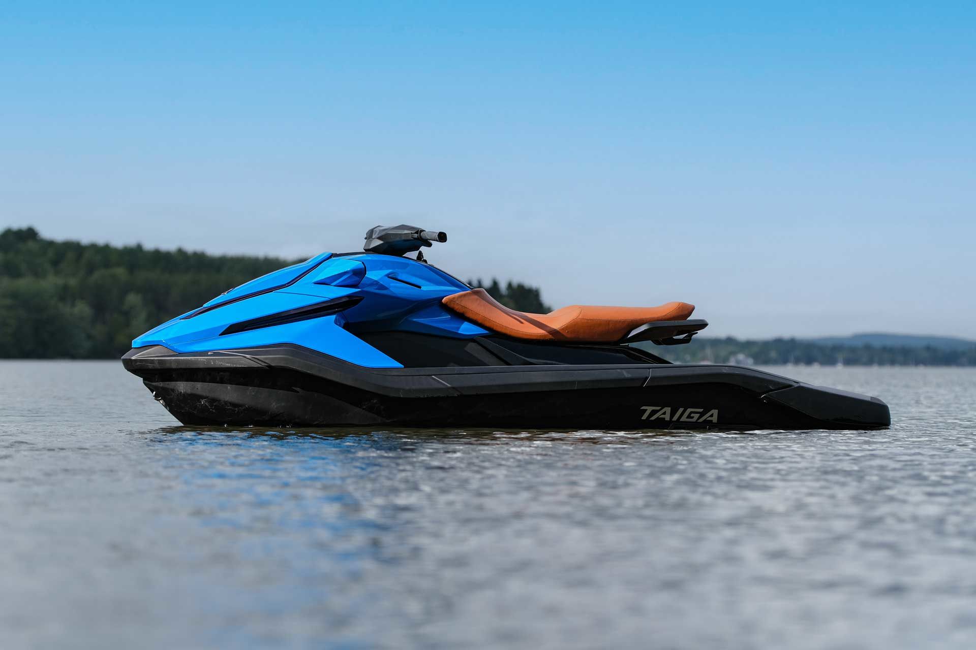 Femme sur une motomarine blanche, faisant des éclaboussures dans l'océan.