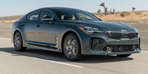 A gray Kia Stinger sedan driving on a highway.
