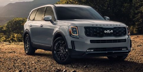 A gray Kia Telluride SUV parked on a dirt road.