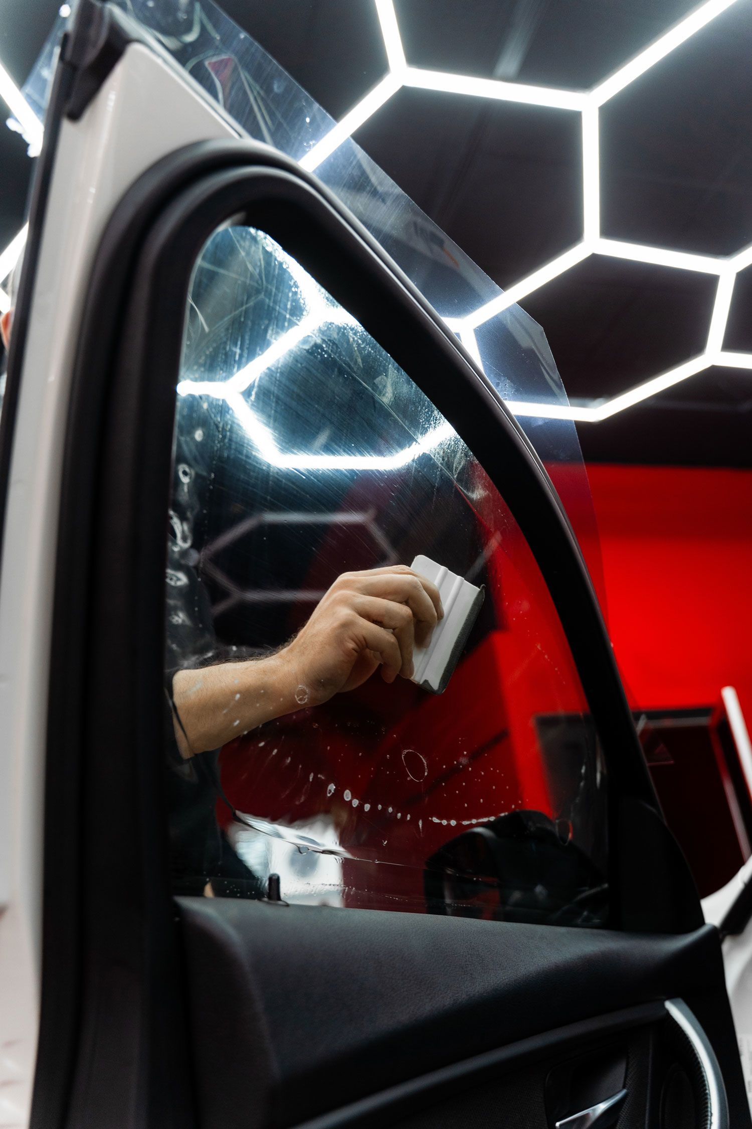 View from inside a car's driver's seat while driving through a tunnel at night, showing light trails.