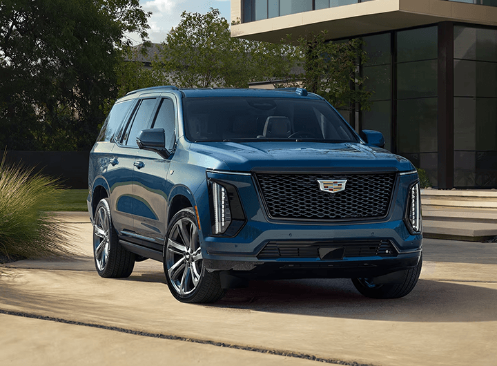 Front view of a blue Cadillac Escalade IQ parked in a driveway.