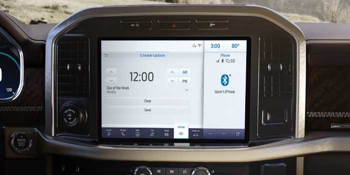 Close-up of a large horizontal infotainment screen integrated into a Ford F-150 truck dashboard, displaying the system update scheduling menu.