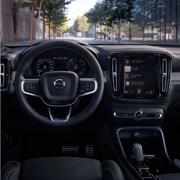 The interior view of a Volvo dashboard, showing the steering wheel, digital instrument cluster, and the central touchscreen display.