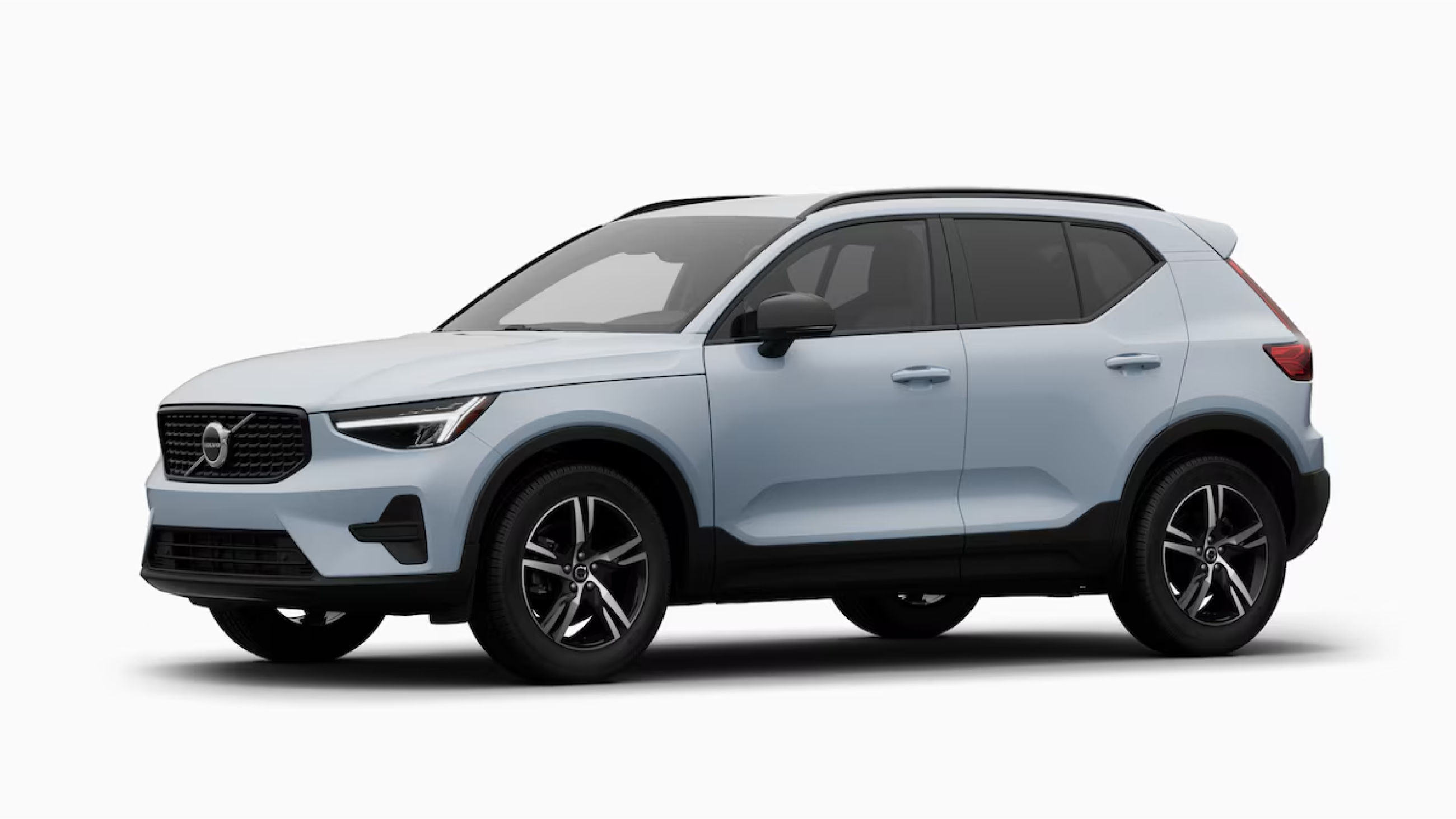 Studio profile view of a light blue Volvo XC40 compact SUV, highlighting its distinct angular rear window design and two-tone alloy wheels against a white background.