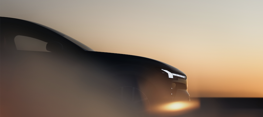 A white sedan speeds down a road, with blue motion blur effects.