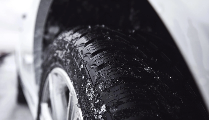 Mechanic giving a thumbs-up sign over a car engine.