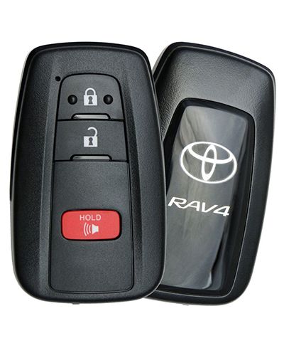 Two black Toyota car key fobs. The front fob shows buttons for lock, unlock, and a red "HOLD" button with a horn icon. The fob behind it is slightly angled and shows the Toyota logo and "RAV4" text on its back.
