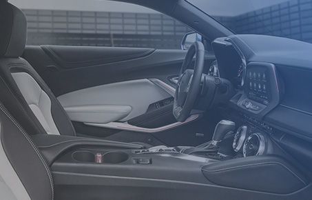 Interior view of a modern vehicle cockpit featuring the steering wheel and dashboard.